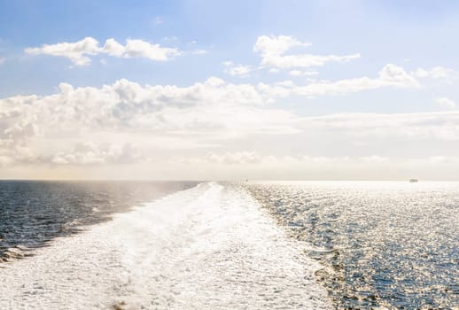 Water trail behind cruise ship. Wave from the ship at sea.