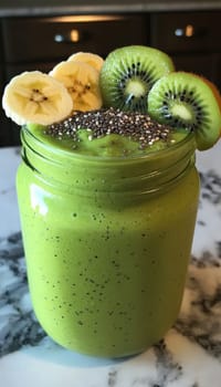 Refreshing green smoothie in a jar, enhanced by layered toppings of chia seeds, sliced bananas, and kiwis. the vivid colors and healthy ingredients make it ideal for nutrition-focused promotions and healthy lifestyle visuals.