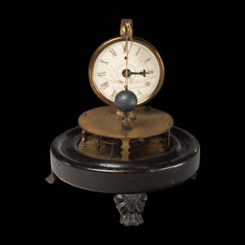 Antique 19th century British perpetual motion clock. The clock features a unique mechanism with a rotating pendulum and intricate gears, showcasing a concept that has fascinated scientists for centuries