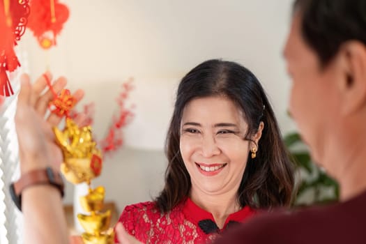 An elderly couple enjoys festive celebrations for Chinese New Year surrounded by vibrant decorations and joyful memories.