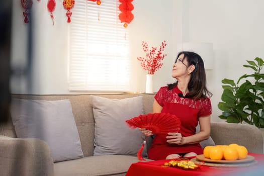 An elderly woman embraces the joy of Chinese New Year surrounded by family and festive decorations in a cozy home.