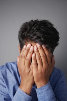 Close up of sad man covering face with hand