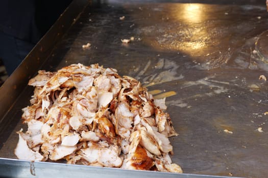 Deliciously cooked, tender shredded meat is sizzling on a hot grill surface, enticing all