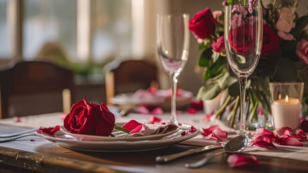 Festive table setting with candles and arrangement of beautiful red flowers. Holiday concept. High quality photo