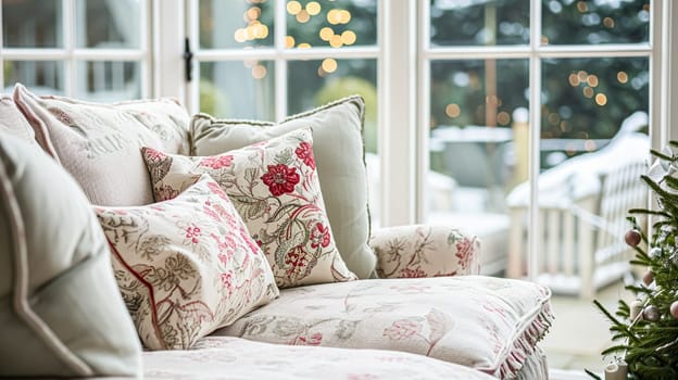 Colorful pillows on sofa against glass wall of window in a winter garden or conservatory. Interior textile concept. High quality photo