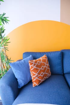 modern blue sofa with orange color pillows in living room at home.