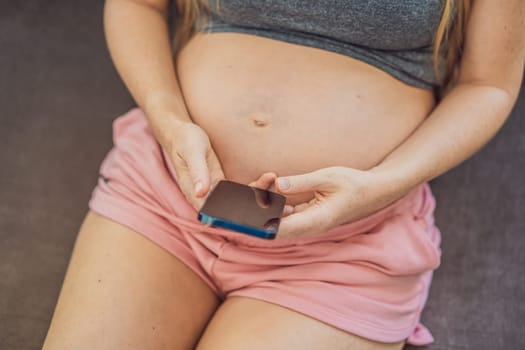 Mobile pregnancy online maternity application. Pregnant mother using phone. Pregnancy, medicine, pharmaceutics, health care and people concept.