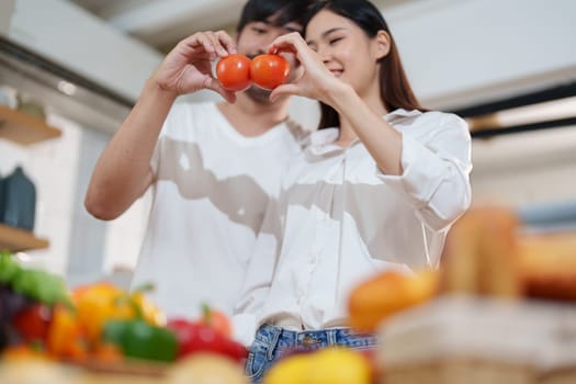 Couple cutting tomatoes for cooking or salad in home kitchen.