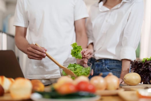 Couple making food or salad in the kitchen at home