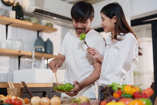 Couple making food or salad in the kitchen at home