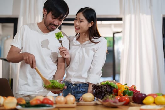 Couple making food or salad in the kitchen at home