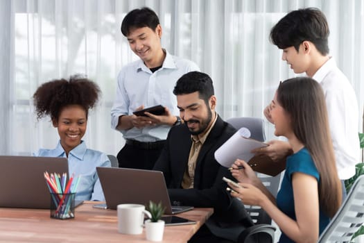 Happy diverse business people work together, discussing in corporate office. Professional and diversity teamwork discuss business plan on desk with laptop. Modern multicultural office worker. Concord