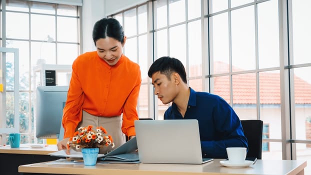 Two business people talk project strategy at office meeting room. Businessman discuss project planning with colleague at modern workplace while having conversation and advice on financial report. Jivy