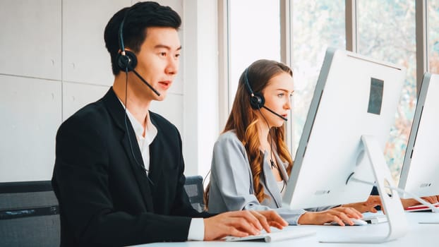 Business people wearing headset working in office to support remote customer or colleague. Call center, telemarketing, customer support agent provide service on telephone video conference call. Jivy