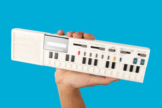 Male hand holding a 90s synth and calculator isolated