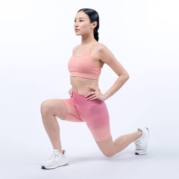 Young attractive asian woman in sportswear stretching before fitness exercise routine. Healthy body care workout with athletic woman warming up on studio shot isolated background. Vigorous