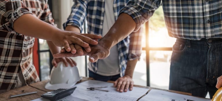 A team of engineers who successfully planned work on a modern home construction project shook hands and congratulated the team on their success..