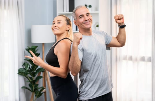 Athletic and sporty senior couple portrait in sportswear with successful or celebrating after overcome struggle posture as home exercise concept with healthy fit body lifestyle after retirement. Clout