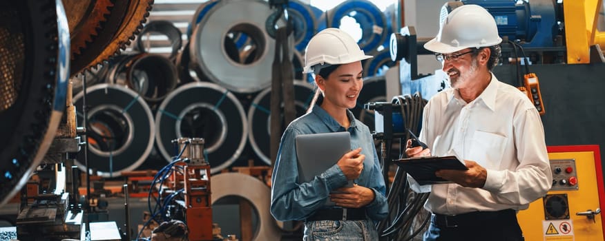 Metalwork manufacturing factory engineer manager conduct inspection of steel industrial machine, exemplifying leadership as machinery engineering inspection supervisor in the facility. Panorama