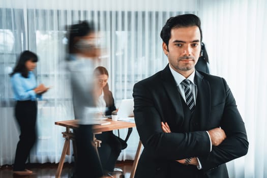 Portrait of happy businessman looking at camera with motion blur background of business people movement in dynamic business meeting. Habiliment