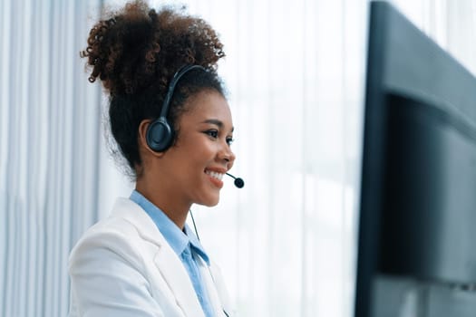 African American young businesswoman wearing headset working in office to support remote crucial customer or colleague. Call center, telemarketing, customer support agent provide service on video call