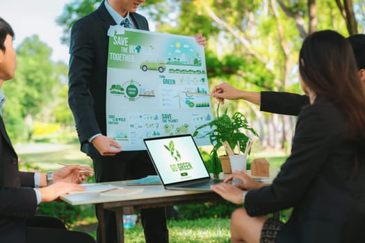 Group of asian business people presenting environmentally friendly development plan and sustainable technology project for greener future, establishing outdoor eco business office at natural park.Gyre