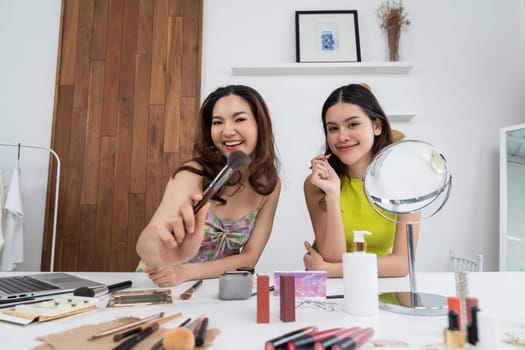 Asian Woman influencer shoot live streaming vlog video review makeup uttermost social media or blog. Happy young girl with cosmetics studio lighting for marketing recording session broadcasting online