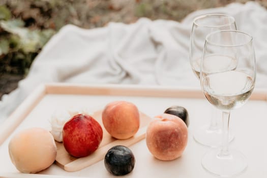 Picnic and wine tasting at sunset in the hills of Italy, Tuscany. Vineyards and open nature in the summer. Romantic dinner, fruit and wine.