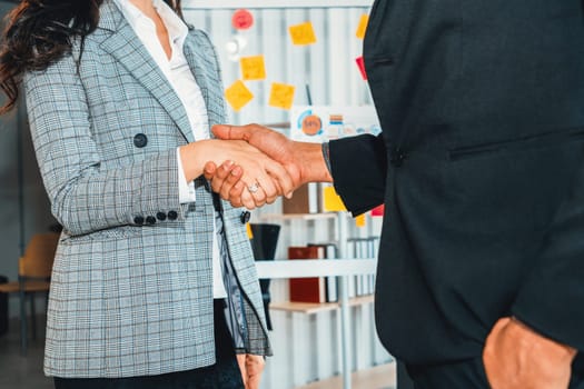 Business people handshake in corporate office showing professional agreement on a financial deal contract. Jivy