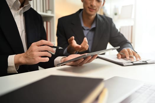 Cropped shot business advisor explaining the contract offering it for the client to sign..
