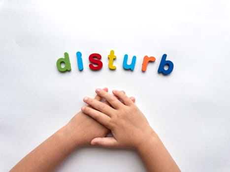 Colorful magnetic letters spelling disturb with childs hands.