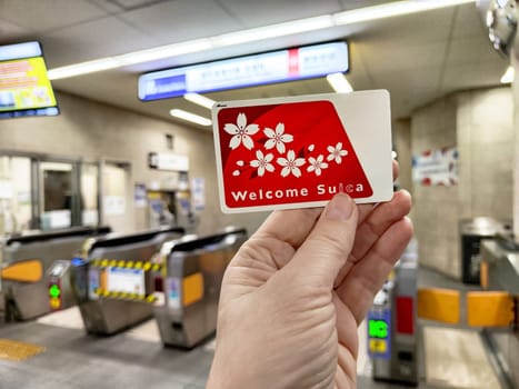 Tokyo, Japan - October 29, 2024: Tourist holds a welcome Suica transport card in a bustling subway station in Japan, ready for easy access to public transit.