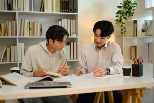 Tutor helping student man with academic tasks. Education and tutoring concept.