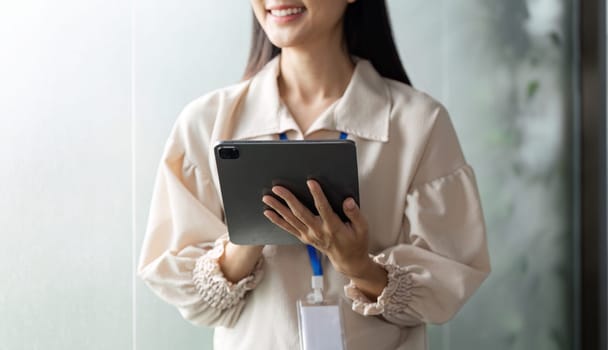 A focused businesswoman uses a tablet in a contemporary office enhancing productivity and collaboration.