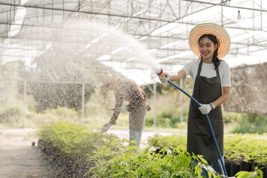 A young woman tends to plants in a greenhouse, showcasing sustainable farming practices and modern agriculture.