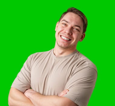 Smiling man in a beige shirt poses against a bright green background in studio