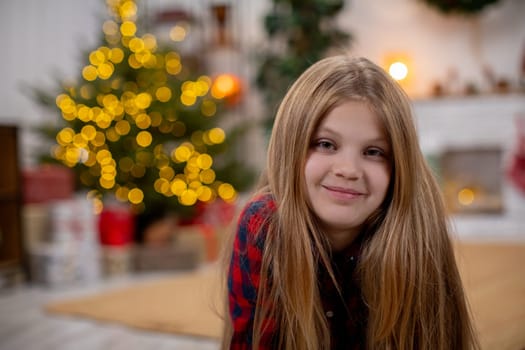 A joyful and cheerful child is surrounded by a warm, festive atmosphere featuring a beautifully lit Christmas tree