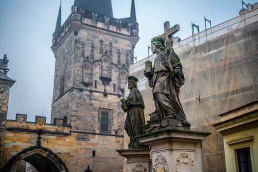 Prague, Czech Republic - 11 October 2024: Mysterious Charles Bridge In Prague: Stone Statues Stand Sentinel Against The Historic Bridge Tower