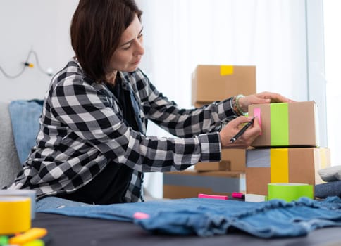 Girl Prepares A Cardboard Box For Shipping And Writes On A Sticker