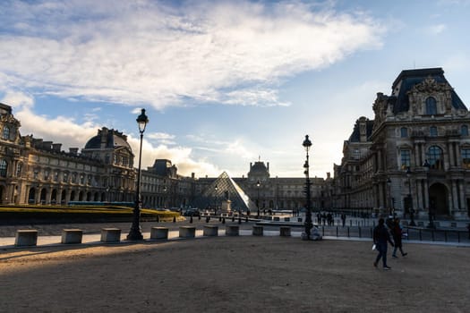 A picturesque scene showcasing the iconic Louvre Pyramid beautifully illuminated against a vibrant sunset sky. Paris, France - October 24, 2024
