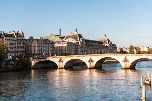 There is an impressive bridge spanning a tranquil body of water, with various buildings visible in the background, Paris, France - October 24, 2024