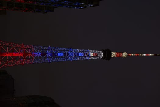 A breathtakingly stunning view of a tall tower beautifully illuminated in patriotic colors during the night