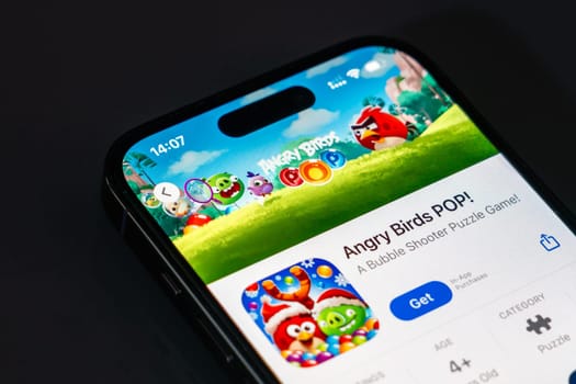 New York, USA - December 20, 2024: Angry Birds POP game app displayed on smartphone screen with logo. Fun mobile puzzle game featuring colorful bubbles and bird characters