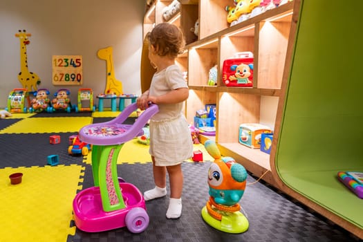 Child actively engaging with a toy cart in a vibrant playroom, surrounded by various educational toys and activities. Concept of fostering creativity and imagination in early childhood