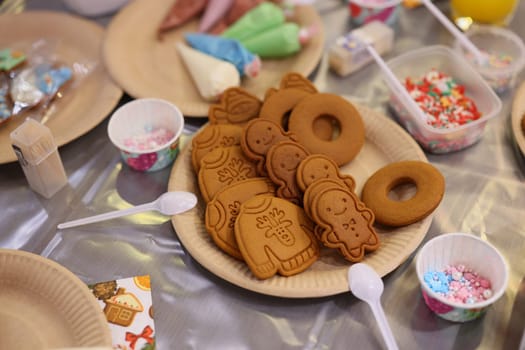 A delightful and beautiful arrangement of gingerbread cookies surrounded by fun and colorful toppings galore