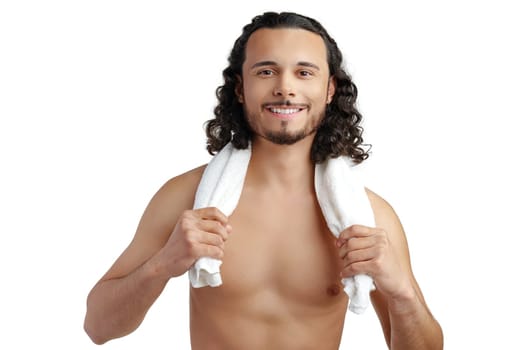 Smiling man with curly hair showing confidence while holding a towel in studio