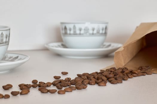 A beautifully arranged coffee scene showcasing an array of beans nestled beside elegant vintage cups, creating charm