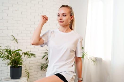 Woman performing a stretching exercise in a bright indoor fitness space