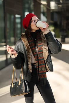 A stylish person enjoys coffee, effortlessly displaying urban fashion in a busy city street atmosphere