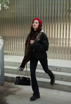 A young woman, dressed in trendy winter attire, walks confidently through a bustling urban environment